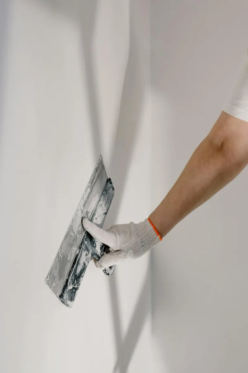 Profesional de reformas trabajando en acabados de pared